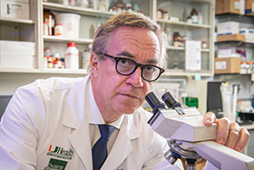 Photo of a scientist with a microscope. Link to Beneficiary Designations.