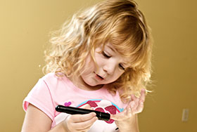Photo of Emma testing her blood sugar. Link to Gifts That Pay You Income.